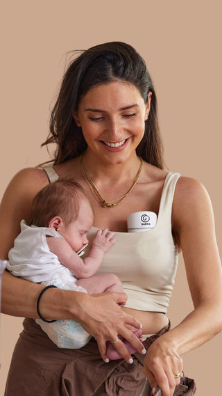 Mum holding bub with bubka breast pump in bra